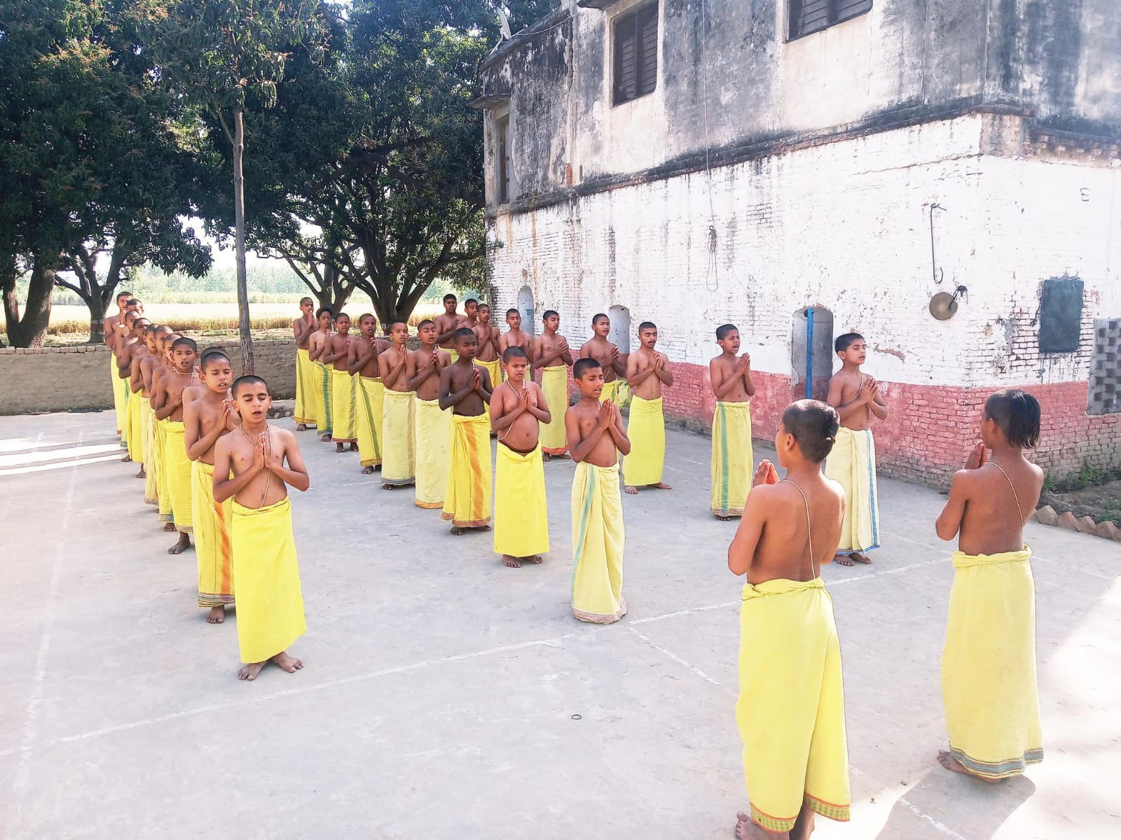 Gurukul students reciting mantras in traditional yellow attire