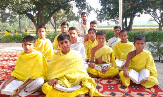 Young Vedic students studying sacred texts outdoors